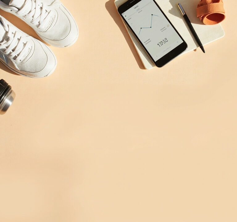 Flatlay d’objets liés au sport et à la stagnation de la perte de poids : baskets, gourde, mètre ruban, smartphone de suivi et carnet